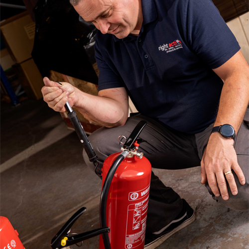 Right Action engineer servicing a fire extinguisher Right Action engineer servicing a fire extinguisher
