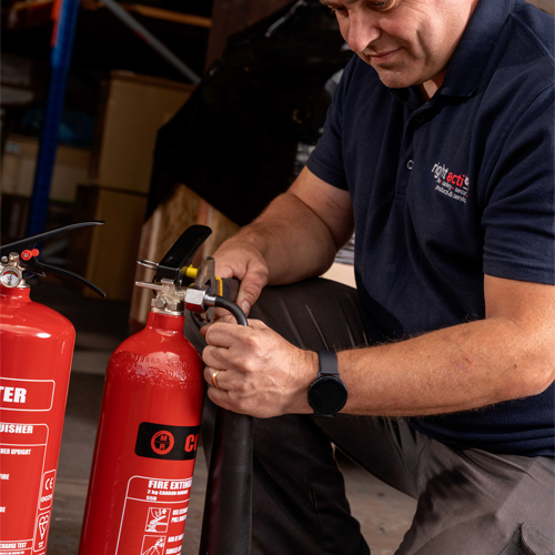 Fire extinguisher engineer servicing a fire extinguisher