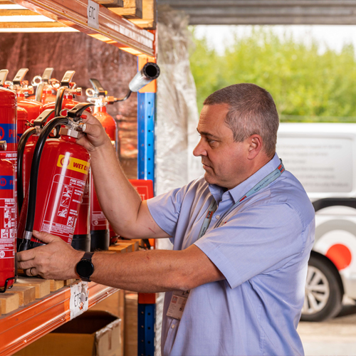 Right Action engineer lifting a fire extinguisher