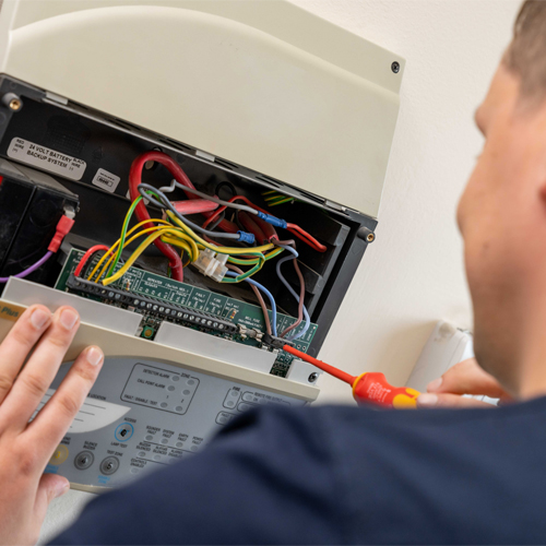 Fire alarm engineer inspecting a fire alarm panel