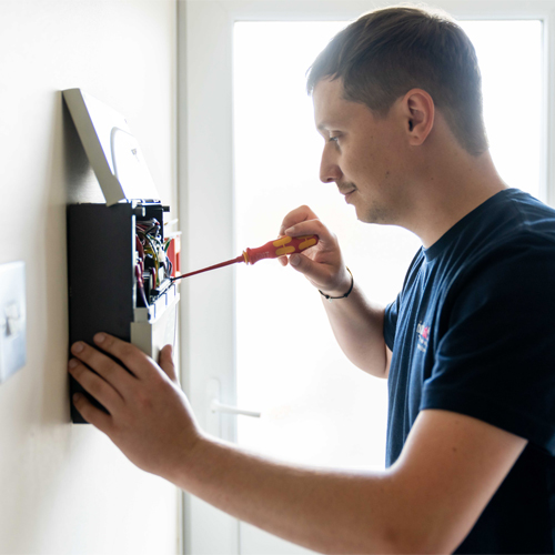 Fire alarm engineer checking a fire alarm panel