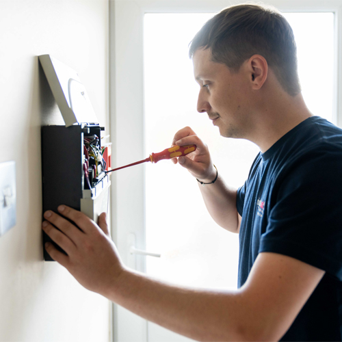 Fire alarm engineer checking a fire alarm panel Fire alarm engineer checking a fire alarm panel