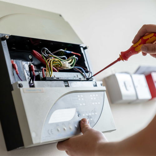 Fire alarm engineer inspecting a fire alarm panel