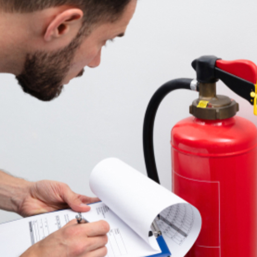 A person inspecting and reporting Fire Extinguisher information on a clipboard.