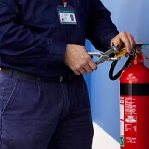 Person applying tool to fire extinguisher