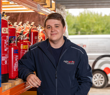 Jake from Right Action stood in front of Fire Extinguishers