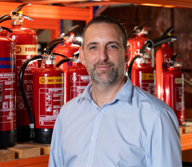 Neil from Right Action stood in front of Fire Extinguishers