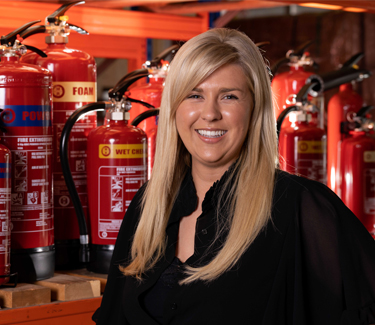 Olivia from Right Action stood in front of Fire Extinguishers